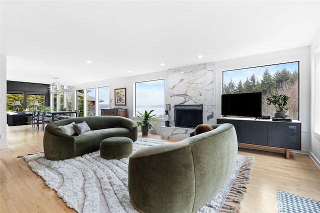 living room with light hardwood / wood-style flooring and a high end fireplace