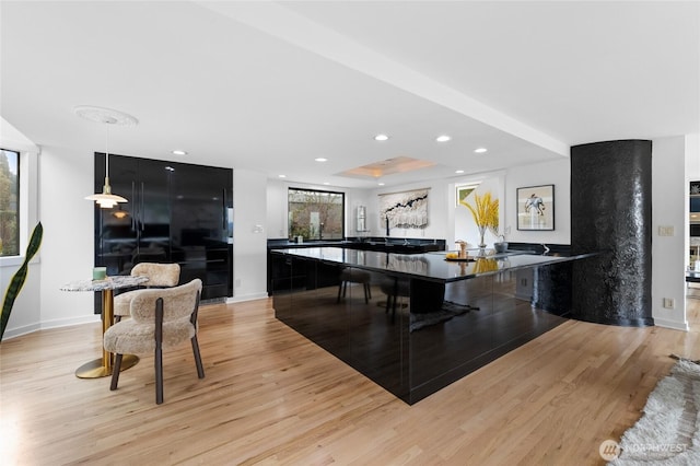 interior space featuring hanging light fixtures, light hardwood / wood-style floors, and a breakfast bar area