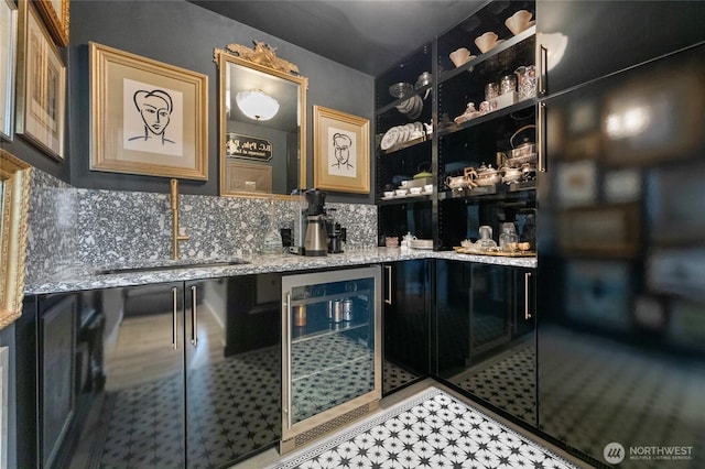 bar with sink, tasteful backsplash, light stone countertops, and wine cooler