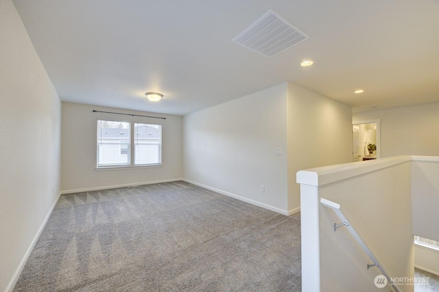 carpeted spare room featuring recessed lighting, baseboards, and visible vents