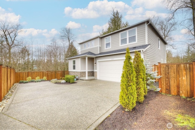 traditional home featuring fence, concrete driveway, roof with shingles, a garage, and stone siding