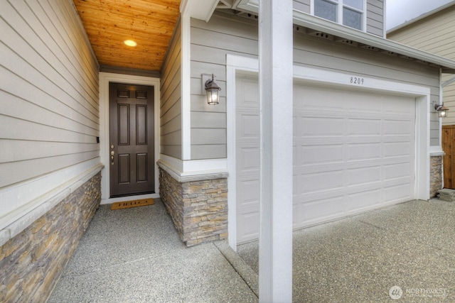 property entrance featuring stone siding and a garage