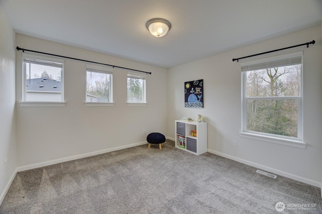 interior space with carpet flooring, baseboards, and visible vents