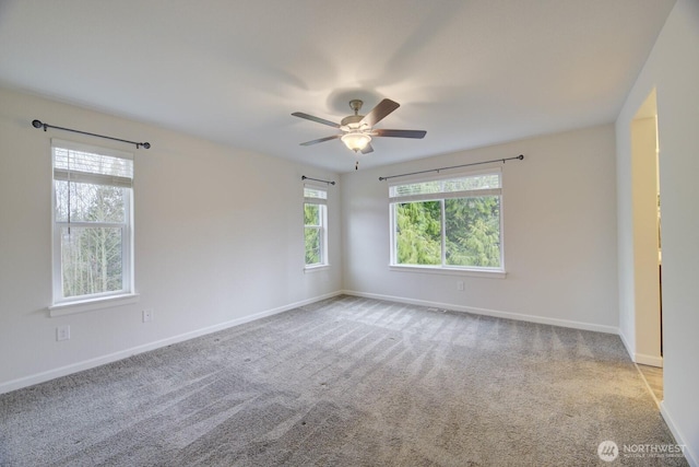 spare room with carpet flooring, baseboards, and ceiling fan