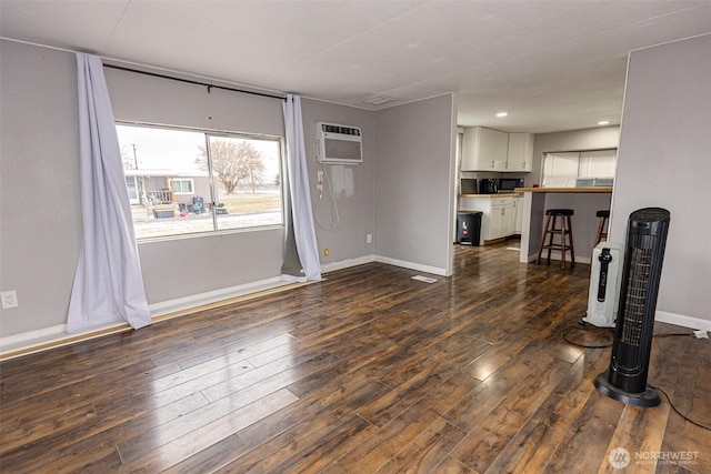 living room featuring a wall mounted AC and dark hardwood / wood-style floors