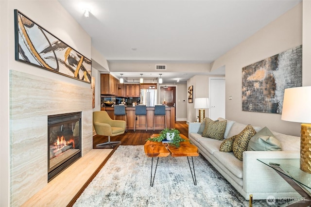 living room featuring a premium fireplace and hardwood / wood-style floors