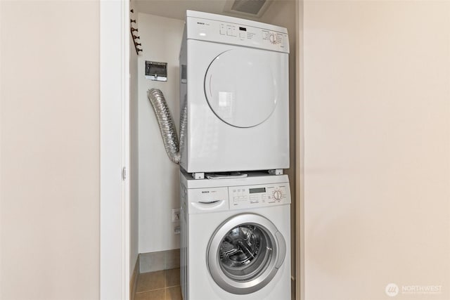 washroom featuring tile patterned floors and stacked washer and dryer