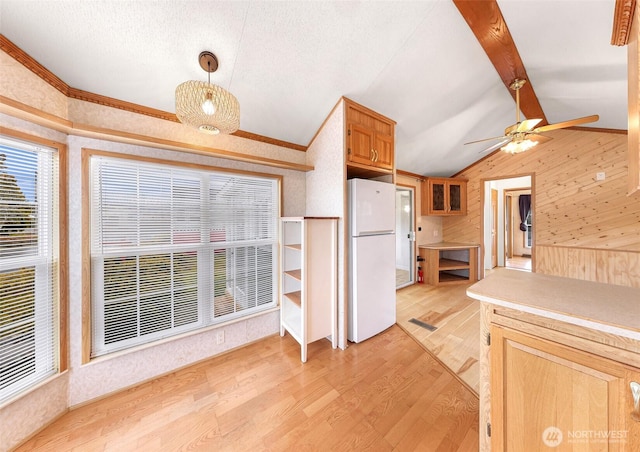 kitchen featuring light wood-type flooring, white fridge, vaulted ceiling with beams, crown molding, and pendant lighting