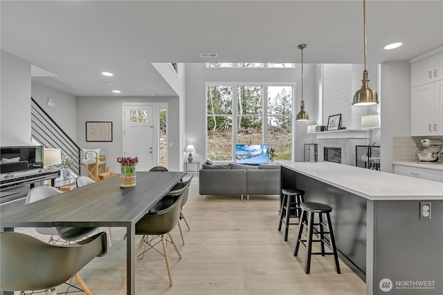 kitchen with open floor plan, light countertops, decorative light fixtures, and white cabinetry