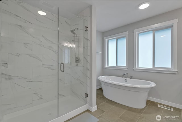 bathroom with a marble finish shower, recessed lighting, a soaking tub, visible vents, and baseboards