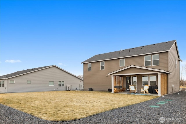 back of property featuring a patio and a lawn