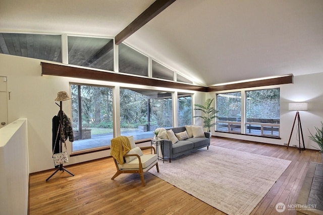 sunroom / solarium featuring vaulted ceiling with beams