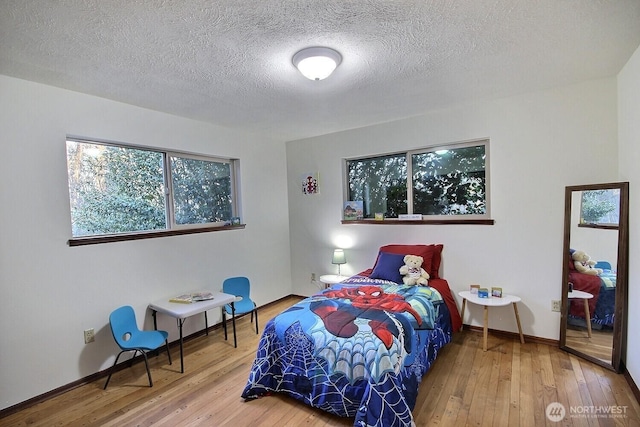 bedroom with hardwood / wood-style flooring and a textured ceiling