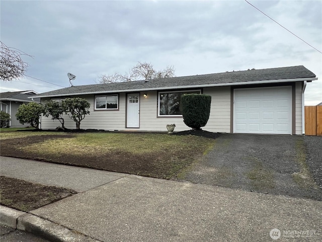 ranch-style home featuring aphalt driveway, a front lawn, a shingled roof, and an attached garage