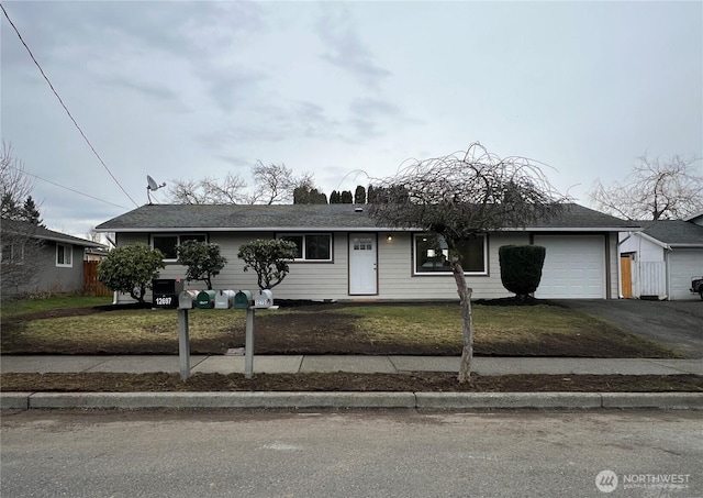 view of front of property with an attached garage, aphalt driveway, and a front yard