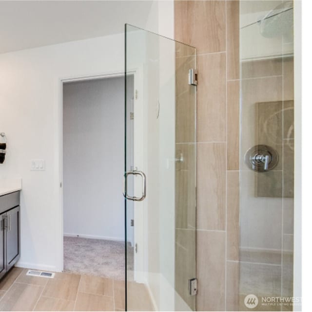 bathroom with vanity and a shower with shower door