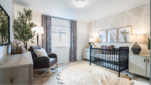 carpeted bedroom featuring a nursery area