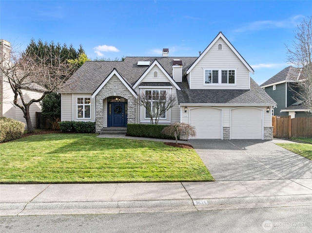 view of front of house with a garage, concrete driveway, stone siding, fence, and a front yard