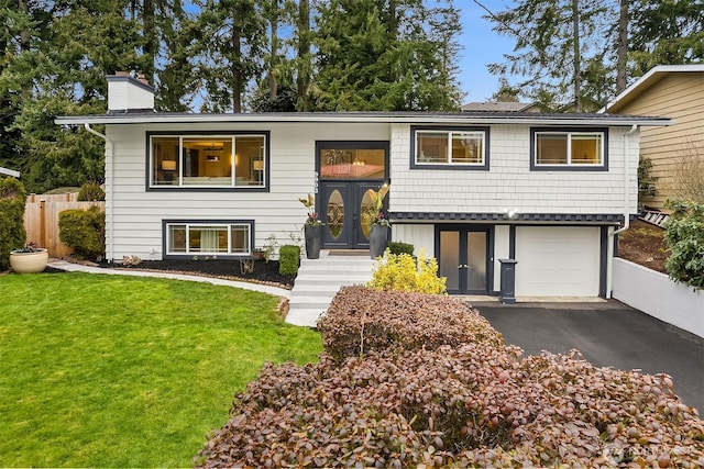 bi-level home with a front lawn and a garage