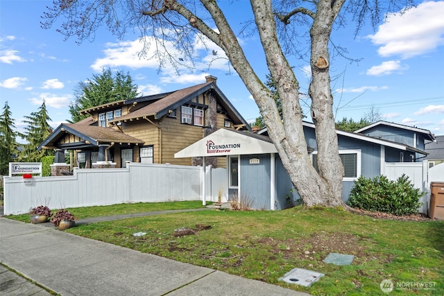 view of front of property with a front yard and fence