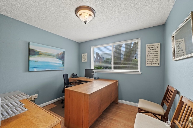 office space with a textured ceiling, baseboards, and wood finished floors