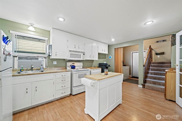 kitchen with white cabinets, white appliances, light wood finished floors, and light countertops