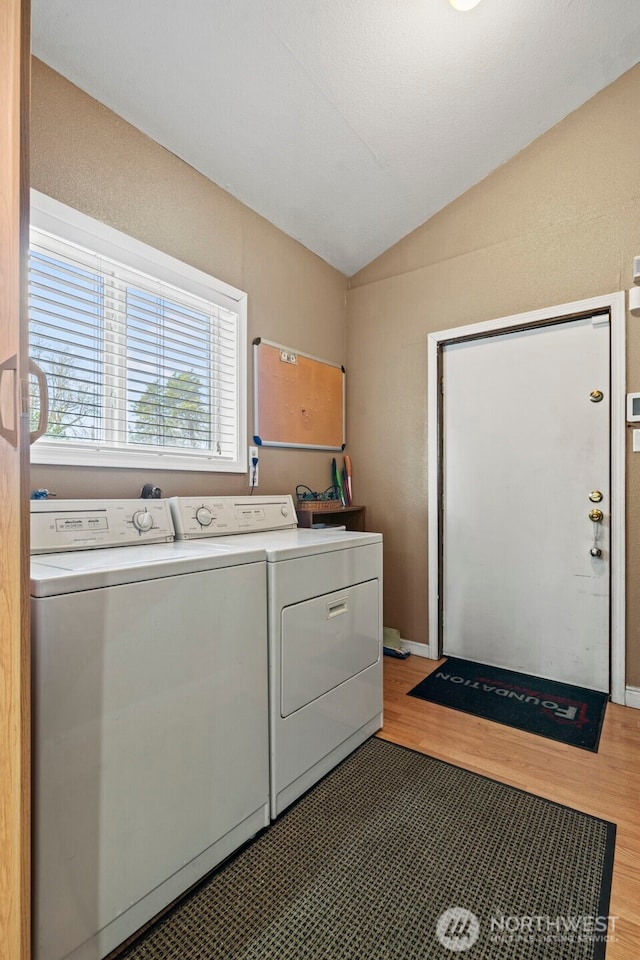 washroom with light wood-style flooring, laundry area, and washer and clothes dryer