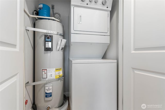 laundry room featuring stacked washer / drying machine and strapped water heater