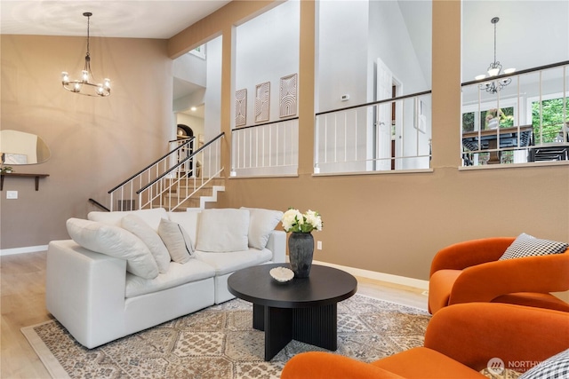 living room featuring hardwood / wood-style floors, an inviting chandelier, and lofted ceiling