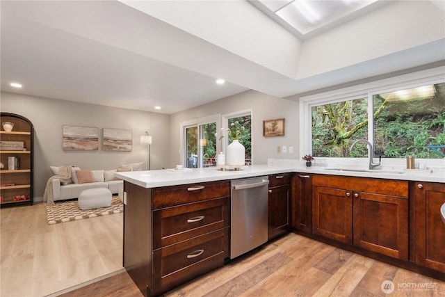 kitchen featuring sink, kitchen peninsula, light wood-type flooring, and dishwasher