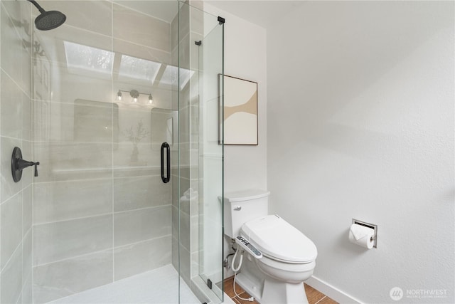 bathroom with toilet, a shower with shower door, and hardwood / wood-style floors