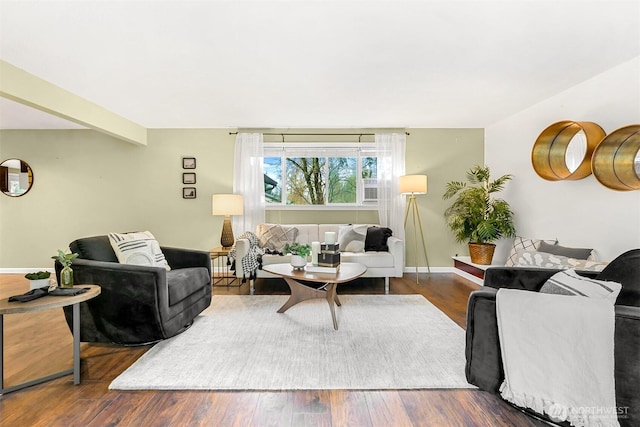 living room featuring dark hardwood / wood-style flooring and beam ceiling