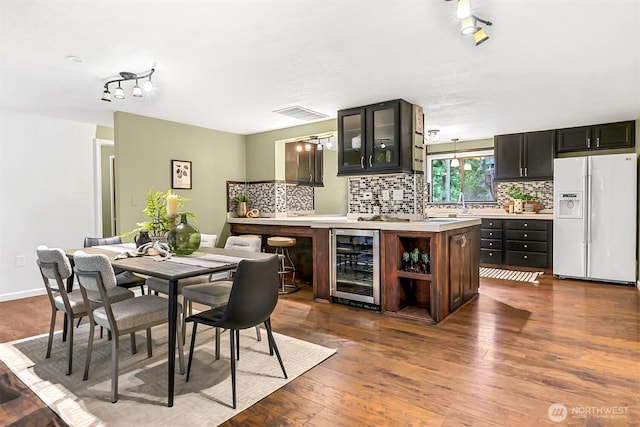 interior space with bar area, beverage cooler, and hardwood / wood-style floors