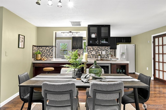 dining room with wine cooler, bar, and dark hardwood / wood-style flooring