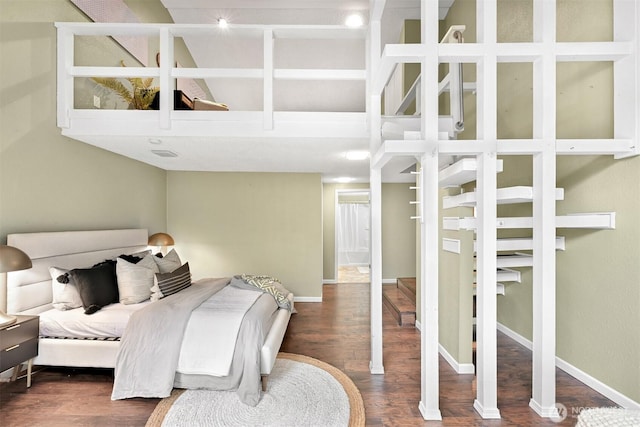 bedroom with dark hardwood / wood-style flooring and a high ceiling