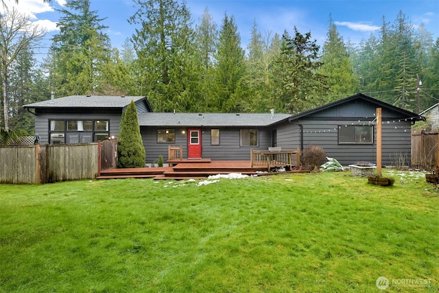 rear view of house with a deck and a lawn