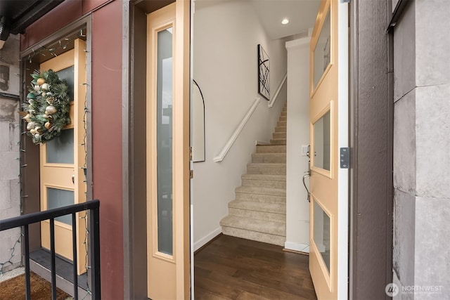 stairs with wood finished floors and recessed lighting