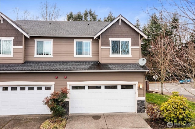 view of front of home with a shingled roof, stone siding, driveway, and a garage