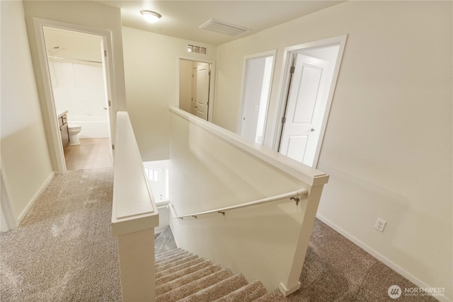 stairs with baseboards, visible vents, and carpet floors