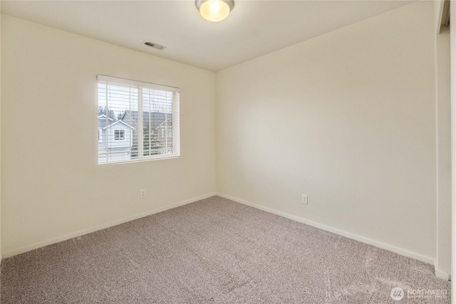 carpeted spare room with baseboards and visible vents