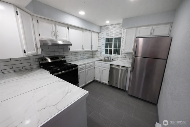 kitchen featuring under cabinet range hood, stainless steel appliances, a sink, white cabinetry, and decorative backsplash