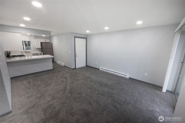 unfurnished living room with a baseboard heating unit, recessed lighting, and dark carpet