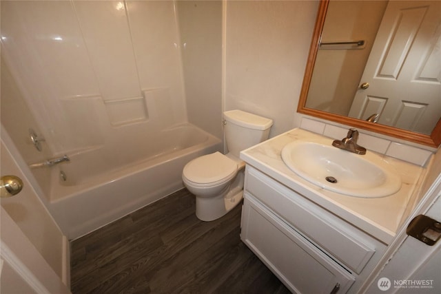 bathroom featuring washtub / shower combination, vanity, toilet, and wood finished floors