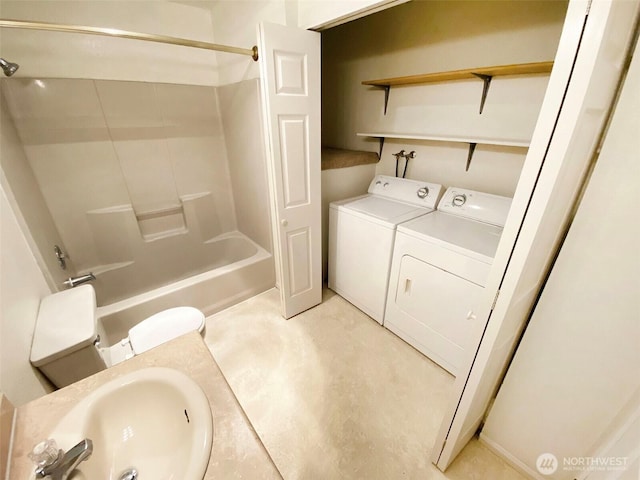 bathroom featuring washtub / shower combination, washer and clothes dryer, and a sink