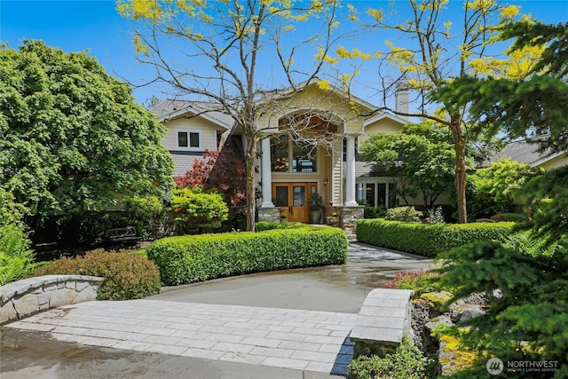 view of front of home featuring french doors and a chimney