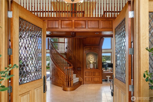 foyer entrance with light tile patterned flooring and stairs