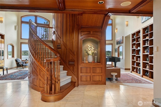 interior space featuring wood ceiling, a towering ceiling, beam ceiling, and tile patterned floors