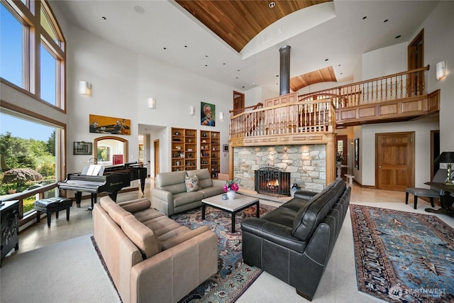 living room featuring light tile patterned floors, a towering ceiling, wood ceiling, a stone fireplace, and built in shelves