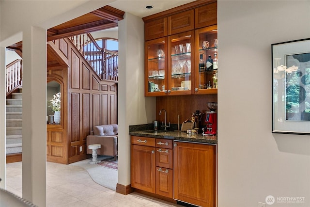 bar featuring wet bar, a sink, stairway, and light tile patterned floors