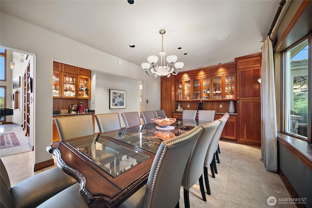 dining room with a chandelier, baseboards, and light tile patterned floors